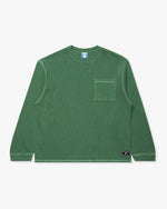 GREEN::A green Undefeated Pigment Dye L/S Pocket tee on a white background.